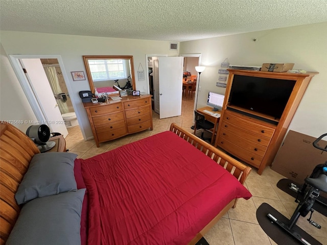 3300 W Rolling Hills Cir Unit 102, Davie, FL 33328 - bedroom featuring light tile patterned floors, a textured ceiling, a spacious closet, and ensuite bathroom