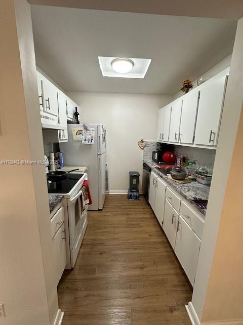 kitchen featuring hardwood / wood-style flooring, white cabinets, and white electric range oven