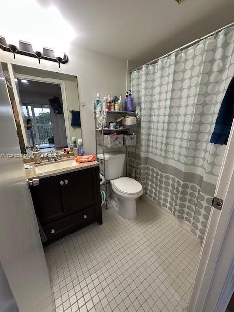 bathroom with toilet, tile patterned flooring, and vanity