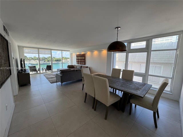 tiled dining space featuring floor to ceiling windows