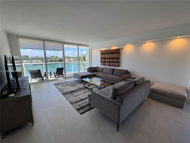 living room featuring light tile patterned floors, expansive windows, and a water view