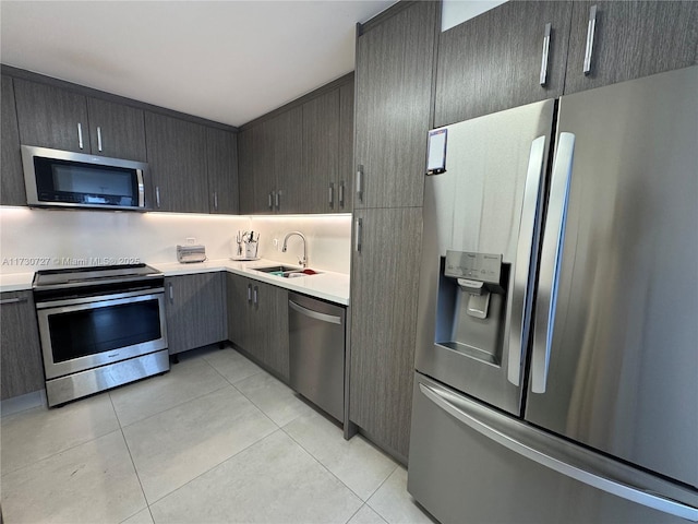 kitchen featuring sink, light tile patterned floors, and appliances with stainless steel finishes