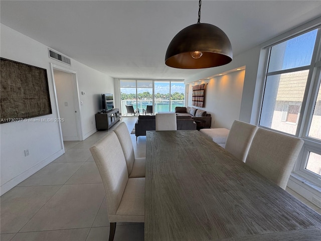 dining room with expansive windows and light tile patterned floors