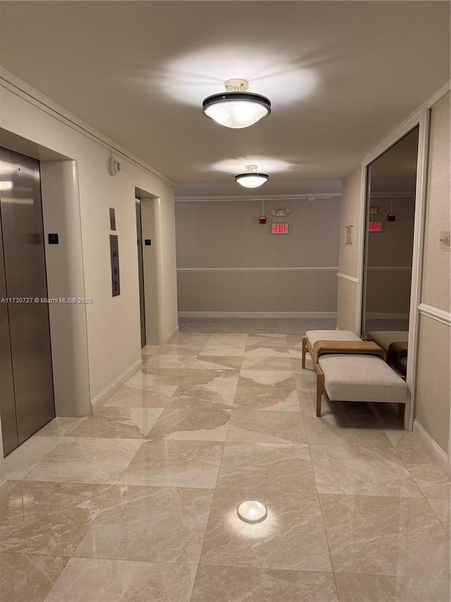 hall with elevator and ornamental molding