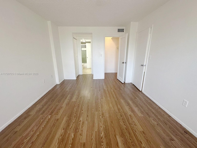 15600 NW 7th Ave Unit 301, Miami, FL 33169 - empty room with light hardwood / wood-style floors and a textured ceiling