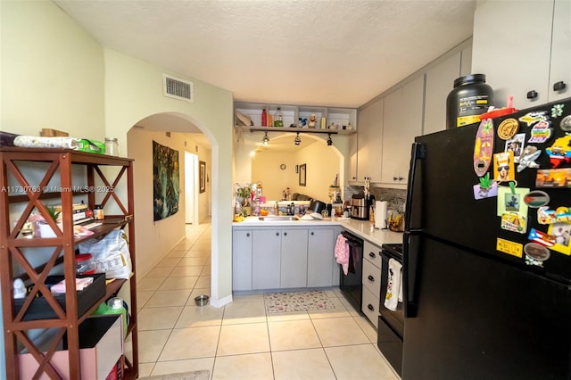 kitchen featuring sink, gray cabinets, light tile patterned flooring, a textured ceiling, and black appliances