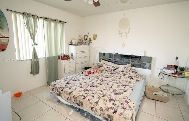 tiled bedroom featuring ceiling fan