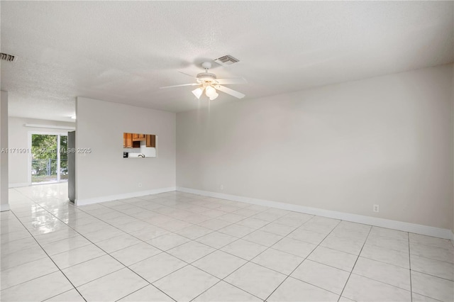 spare room featuring light tile patterned flooring, a textured ceiling, and ceiling fan