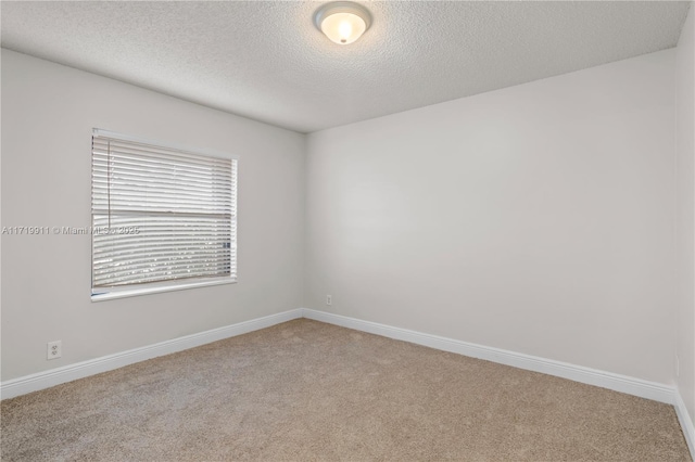 carpeted spare room featuring a textured ceiling