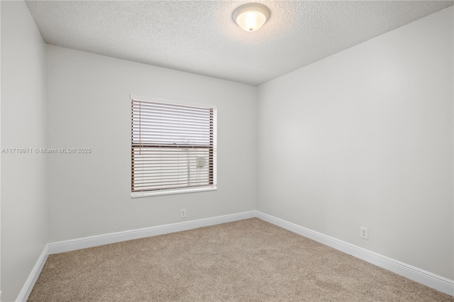 spare room with a textured ceiling and light carpet