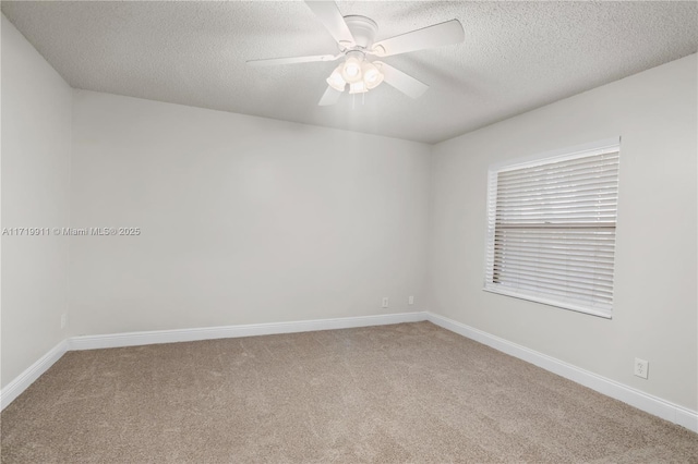 carpeted spare room featuring ceiling fan and a textured ceiling