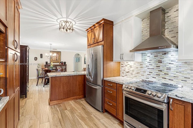 kitchen featuring decorative light fixtures, wall chimney range hood, stainless steel appliances, backsplash, and ornamental molding