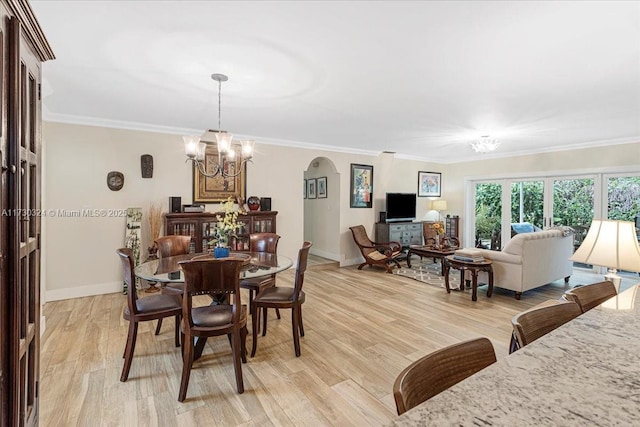 dining space featuring light hardwood / wood-style floors, a notable chandelier, and ornamental molding