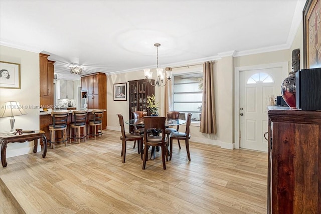 dining room featuring crown molding, an inviting chandelier, and light hardwood / wood-style flooring