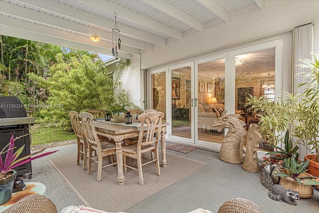 sunroom featuring beam ceiling