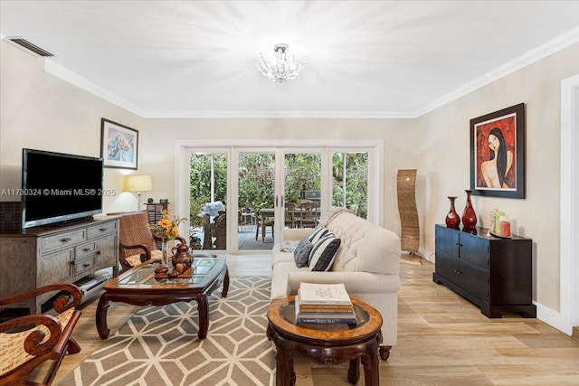 living room with a chandelier, crown molding, and light hardwood / wood-style floors