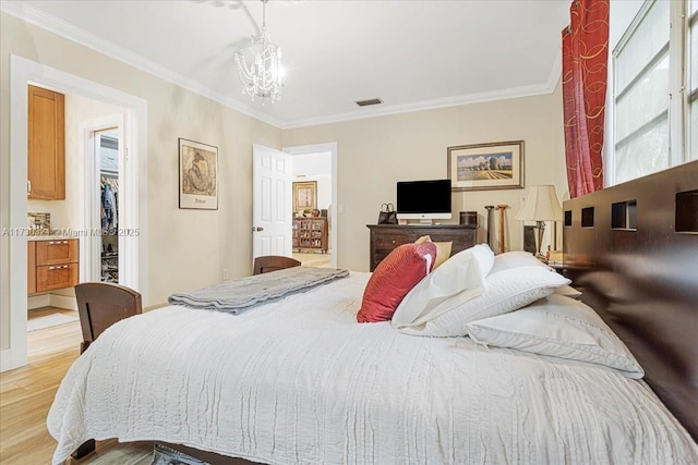 bedroom with light hardwood / wood-style floors, ornamental molding, and a chandelier