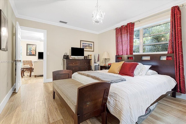 bedroom with crown molding, light hardwood / wood-style floors, and an inviting chandelier