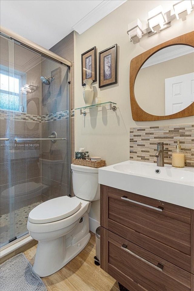 bathroom featuring decorative backsplash, wood-type flooring, toilet, and a shower with door