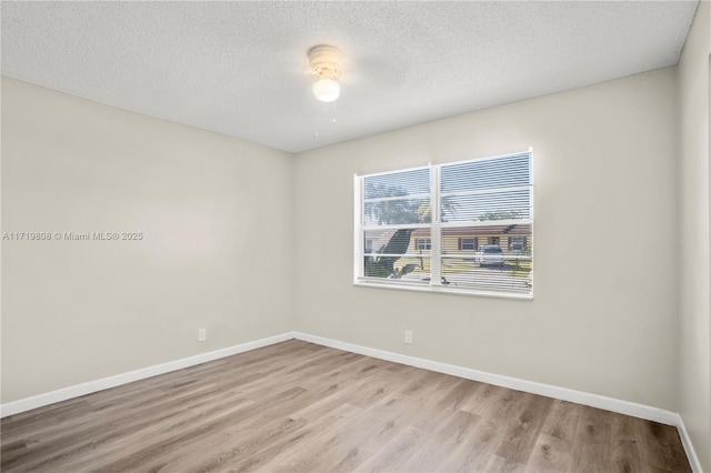 spare room with light wood-type flooring, a textured ceiling, and ceiling fan