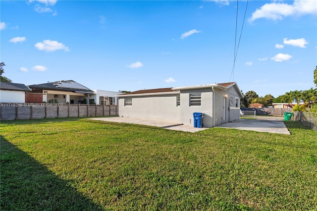 back of property with a patio area and a yard