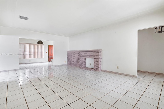 unfurnished living room featuring light tile patterned floors and a brick fireplace