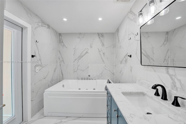 bathroom featuring vanity, a bathtub, and tile walls