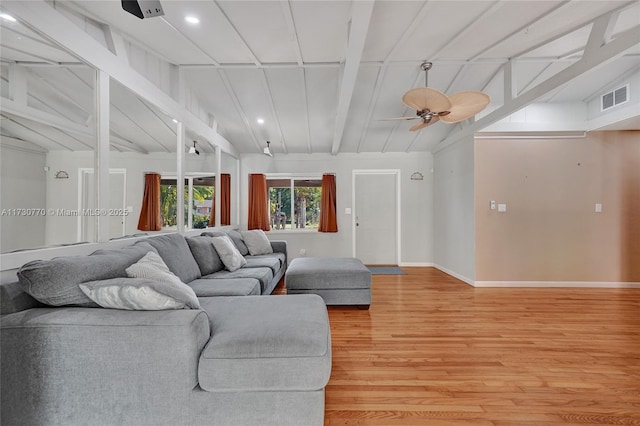 living room with hardwood / wood-style flooring, vaulted ceiling with beams, and ceiling fan