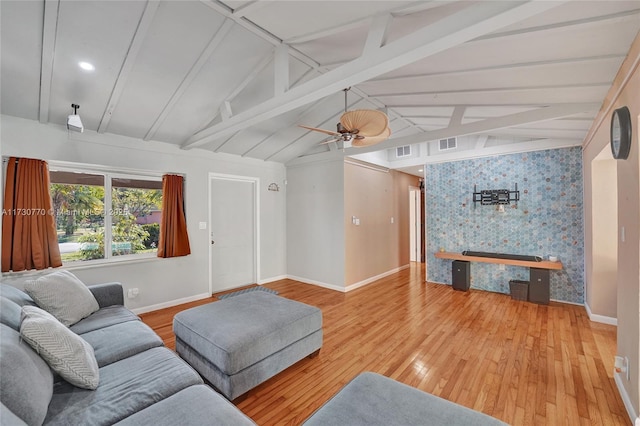 living room with lofted ceiling with beams, ceiling fan, and light wood-type flooring