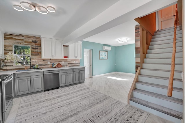 kitchen featuring gray cabinets, tasteful backsplash, sink, white cabinets, and stainless steel appliances