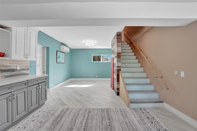 staircase featuring a wall mounted air conditioner and wood-type flooring