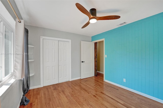 unfurnished bedroom featuring a closet, ceiling fan, and light wood-type flooring