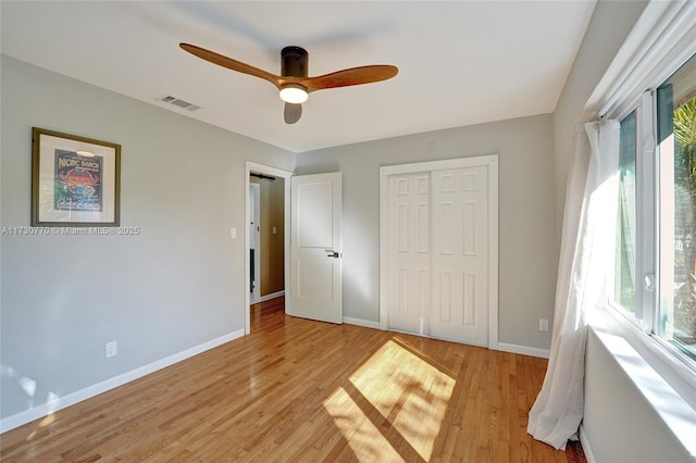 unfurnished bedroom with ceiling fan, a closet, and light wood-type flooring