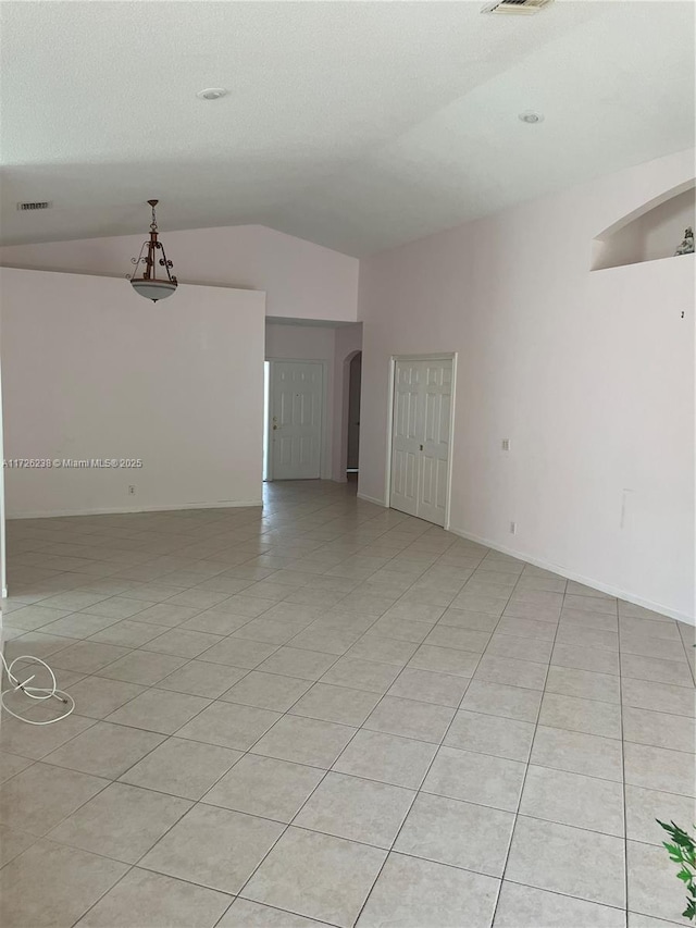 10495 S Utopia Cir S, Boynton Beach, FL 33437 - empty room with vaulted ceiling, light tile patterned flooring, and arched walkways