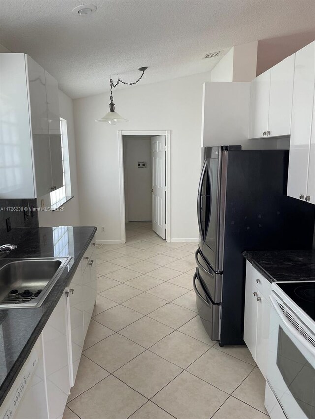 10495 S Utopia Cir S, Boynton Beach, FL 33437 - kitchen featuring white appliances, dark countertops, white cabinets, a textured ceiling, and light tile patterned floors