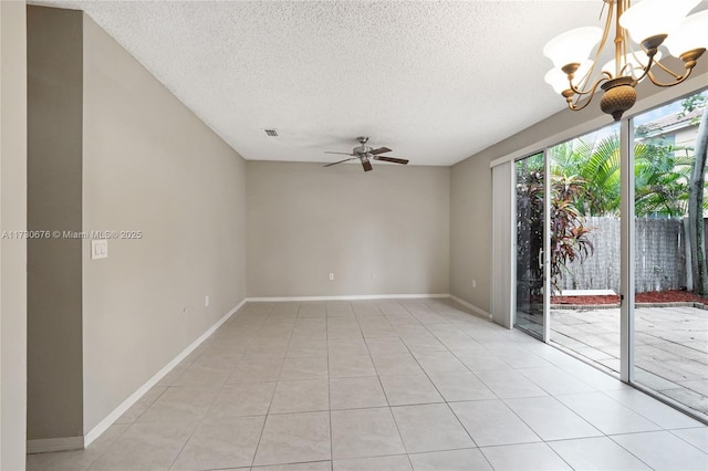 empty room with light tile patterned floors, ceiling fan with notable chandelier, and a textured ceiling