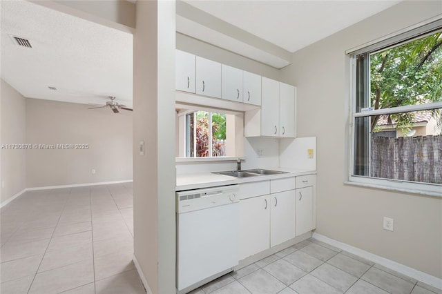 kitchen featuring white cabinetry, sink, white dishwasher, and a healthy amount of sunlight