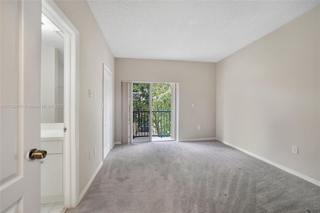 empty room with light carpet and a textured ceiling