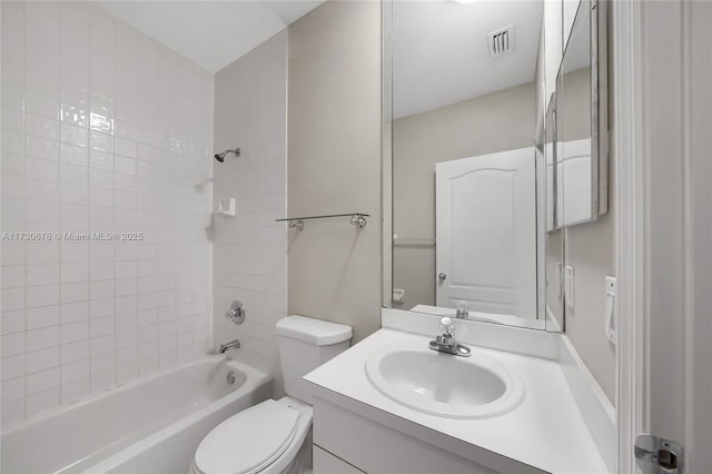 full bathroom featuring tiled shower / bath, vanity, and toilet