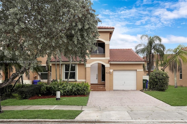 mediterranean / spanish-style home featuring a garage and a front lawn