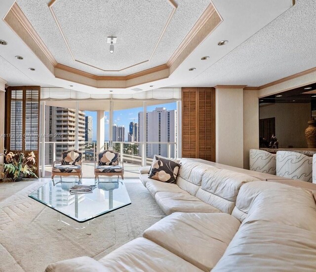 living room with a wall of windows, ornamental molding, and a raised ceiling