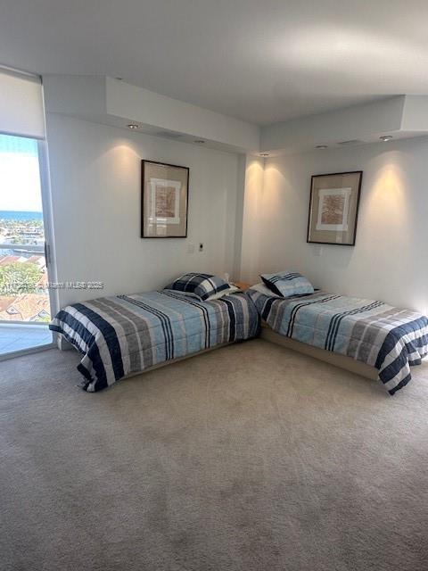 bedroom featuring access to exterior, carpet, and a textured ceiling