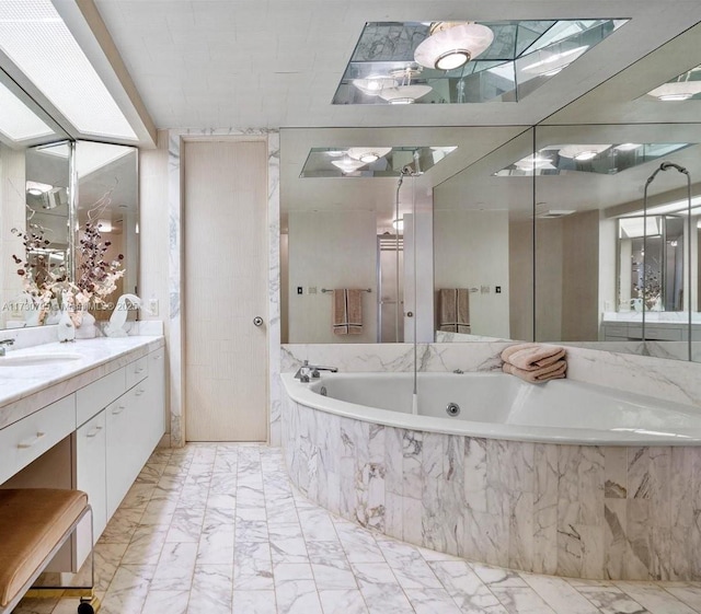 bathroom with vanity and a relaxing tiled tub