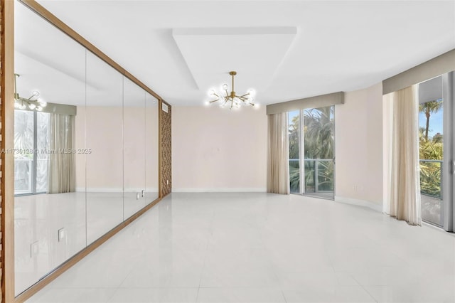 tiled empty room featuring a chandelier