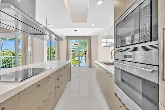 kitchen featuring pendant lighting, black electric stovetop, oven, light tile patterned floors, and built in microwave