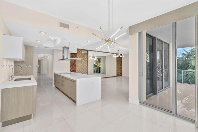 kitchen featuring light brown cabinetry, black electric stovetop, a chandelier, light tile patterned floors, and island range hood