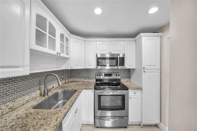 kitchen with sink, white cabinetry, decorative backsplash, and stainless steel appliances