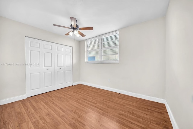 unfurnished bedroom featuring ceiling fan, wood-type flooring, and a closet