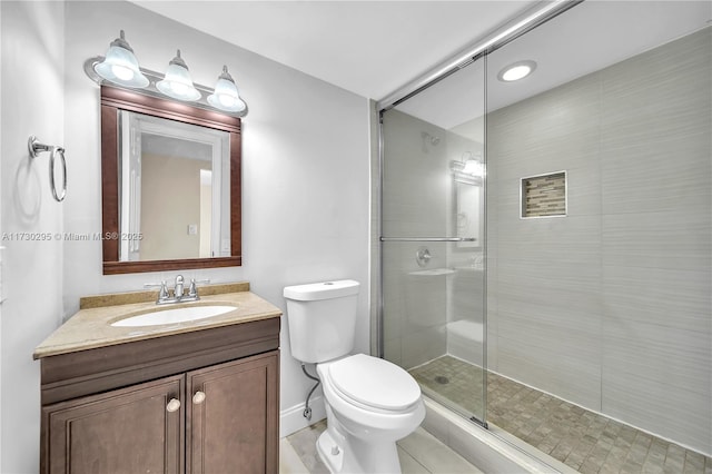 bathroom with a shower with shower door, toilet, vanity, and tile patterned flooring