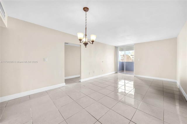 tiled spare room featuring an inviting chandelier